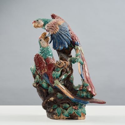 une figurine représentant deux perroquets perchés sur une branche d'arbre
