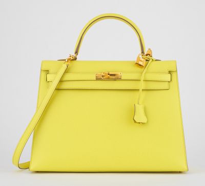 un sac à main en cuir jaune avec des finitions dorées sur la poignée