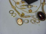 a lot of gold jewelry on a white table