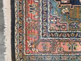 an antique persian rug on a wooden floor with a blue background