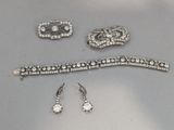 trois bijoux en argent, à savoir un bracelet, une broche et des boucles d’oreilles
