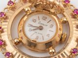 an image of a close up of a gold clock with pink stones