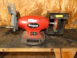 une ponceuse électrique rouge posée sur une table en bois