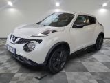 the white nissan juke suv is parked in the garage