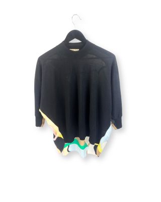 un pull noir orné d'un motif multicolore, suspendu à un cintre