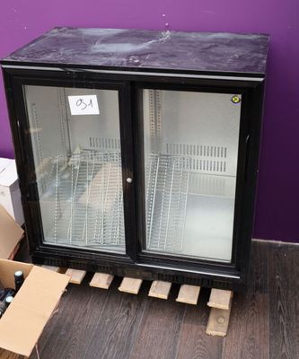 a black refrigerator with a glass door and a box of wine