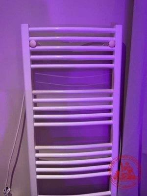 un porte-serviettes blanc orné d'une lumière violette