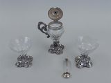 a silver and glass set with a spoon and spoon rest