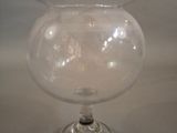 un vase en verre transparent bordé d'argent, posé sur une table