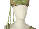 une image représentant une coiffe de mannequin aux motifs verts et dorés