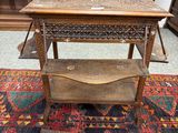 an old wooden table with a shelf on top of a rug