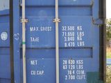 a blue shipping container that is sitting on the side of the road