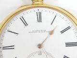 a gold pocket watch with roman numerals on the face