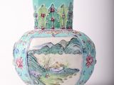 a blue vase with a painting on it sitting on a table