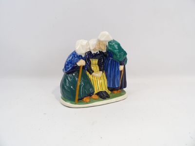 une figurine représentant trois personnes assises sur un banc