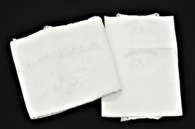 deux serviettes blanches ornées de motifs brodés sur fond noir