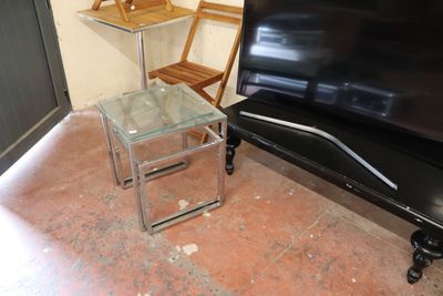a glass table and a black piano in a room
