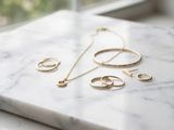 un plan de travail en marbre sur lequel sont posés des bijoux en or