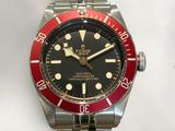 a red and black watch on a silver bracelet