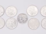 a group of silver coins sitting on top of a white surface