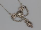an image of a silver cross necklace with a flower design on a chain