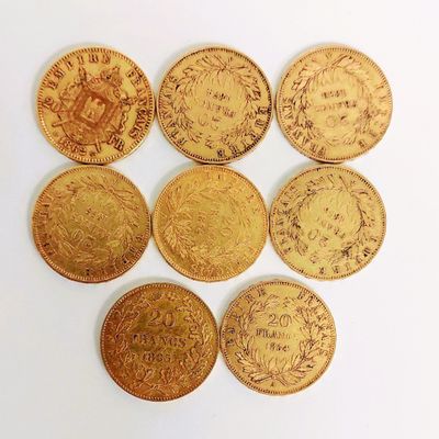 six types différents de pièces d'or disposées sur une surface blanche