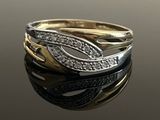 a close up of a gold and silver ring with diamonds