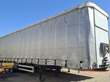 un camion garé sur un terrain avec d'autres camions à l'arrière-plan