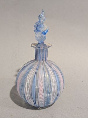 un vase bleu et blanc surmonté d'un oiseau