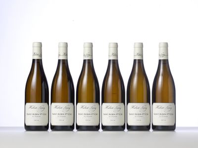 six bottles of white wine lined up on a table