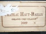 une boîte en bois sur laquelle est collée une étiquette portant l'inscription « Château Haute - Bally »