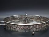 silver plated serving dish with handles and handles on a black surface