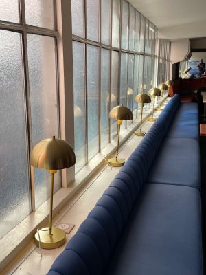 a long blue couch sitting in front of a window next to a blue couch