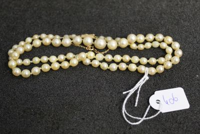 un collier de perles blanches avec une étiquette sur un fond noir