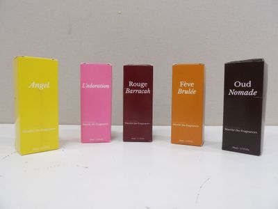 four boxes of perfume are lined up on a white surface