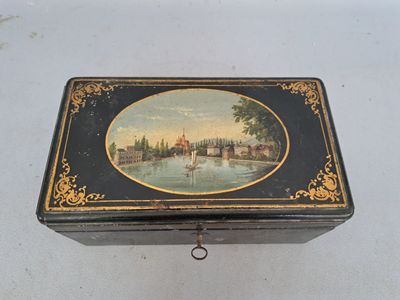 une boîte noire et dorée ornée d'une peinture