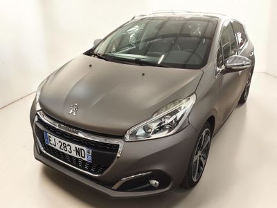 La voiture grise est garée dans une pièce blanche au sol blanc.
