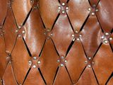 a close up of a brown leather bag with rivets on it