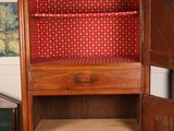 an old wooden cabinet with a red cloth covering it