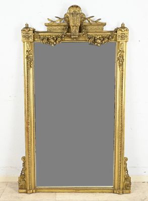 an ornate gold framed mirror with a bird on top of it