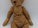 un ours en peluche marron assis sur une surface blanche