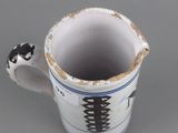 a white cup with a black and white design on it