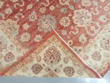 a red and beige rug on a white surface