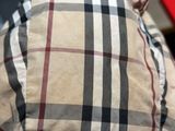 a close up of a man ' s plaid shirt with a cell phone in his hand