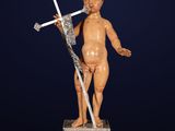 une statue représentant un enfant coiffé d'une couronne et tenant une épée