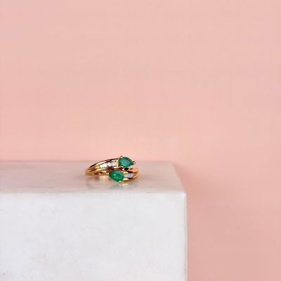 a close up of a gold ring with a green stone on top