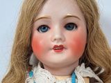 a close up of a doll with a necklace on it