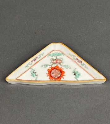 a close up of a triangle shaped plate with a flower design on it