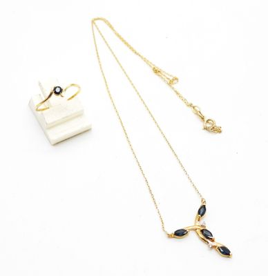 a close up of a necklace and earring on a white surface