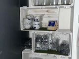 a refrigerator that has a bunch of dishes and glasses on it